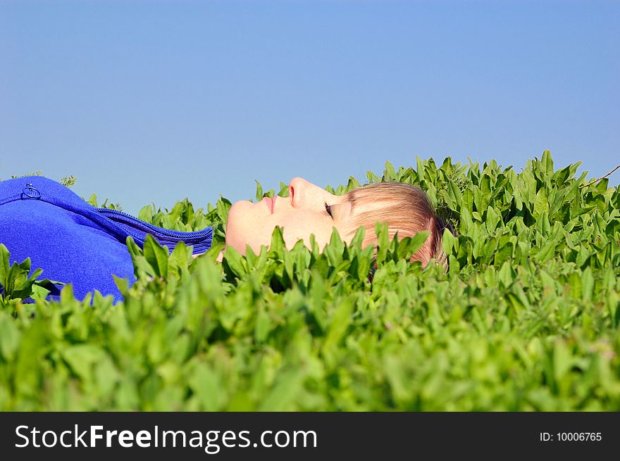 The teenager lays in a spring grass. The teenager lays in a spring grass
