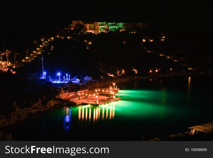 Night time photo of a pier at a tropical resort