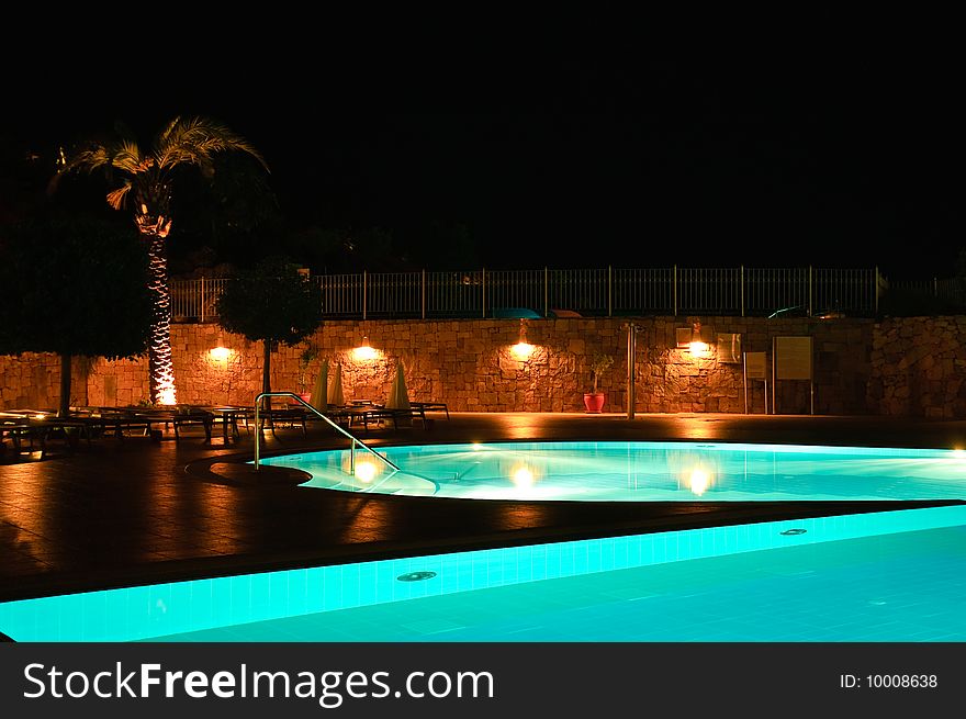 Night time photo of a swimming pool at a tropical resort