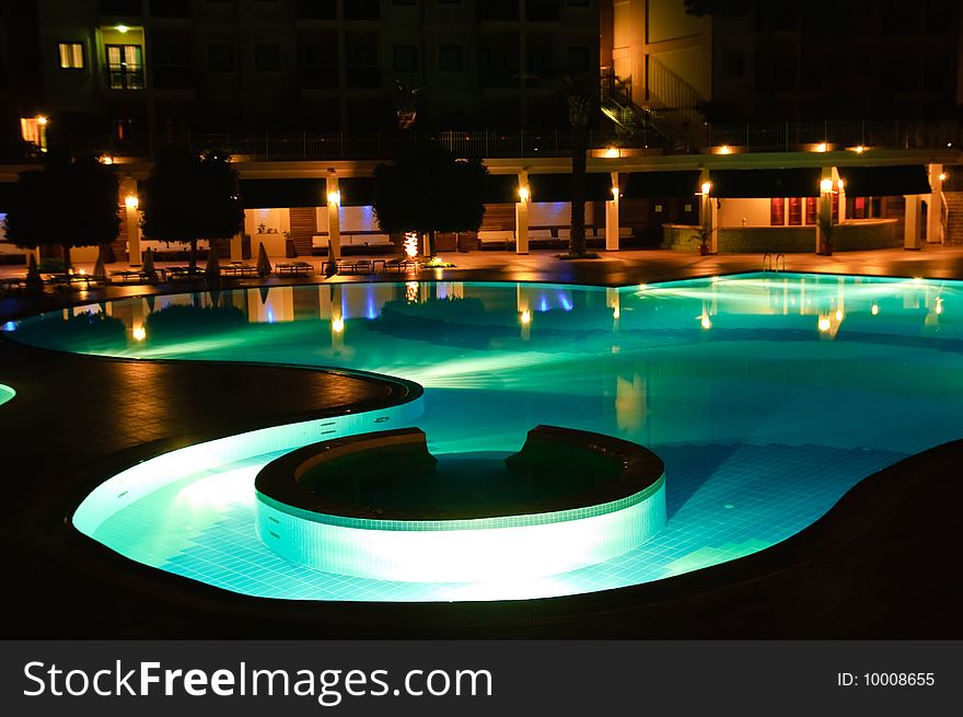 Night time photo of a swimming pool at a tropical resort