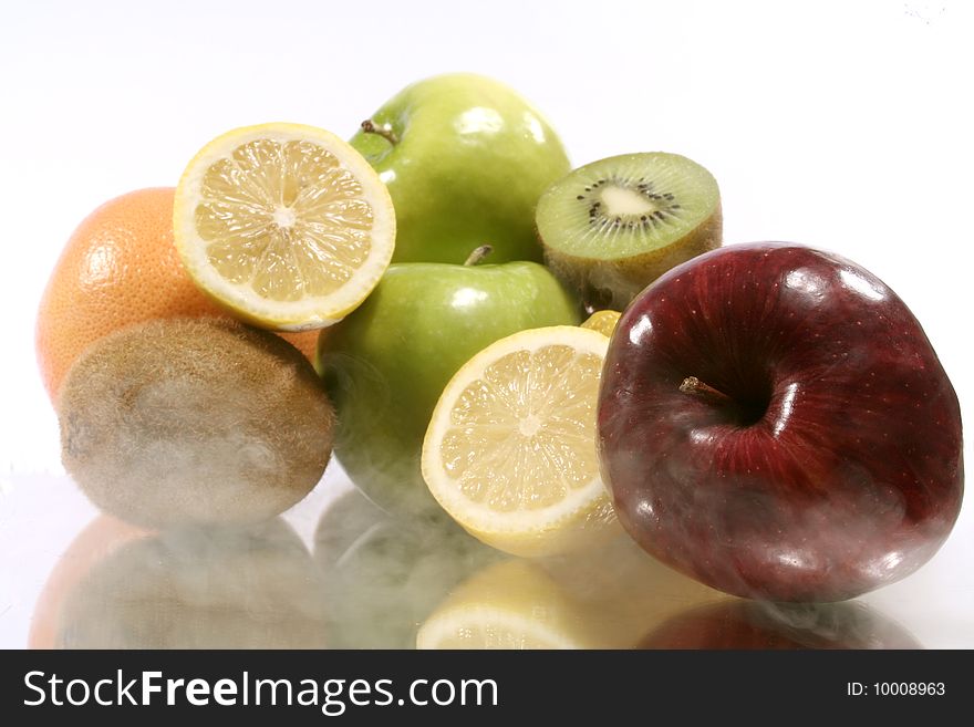 Assorted fruits with their reflection and smoke