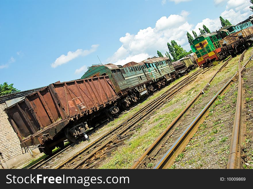 Unserviceable trains on rails under blue sky