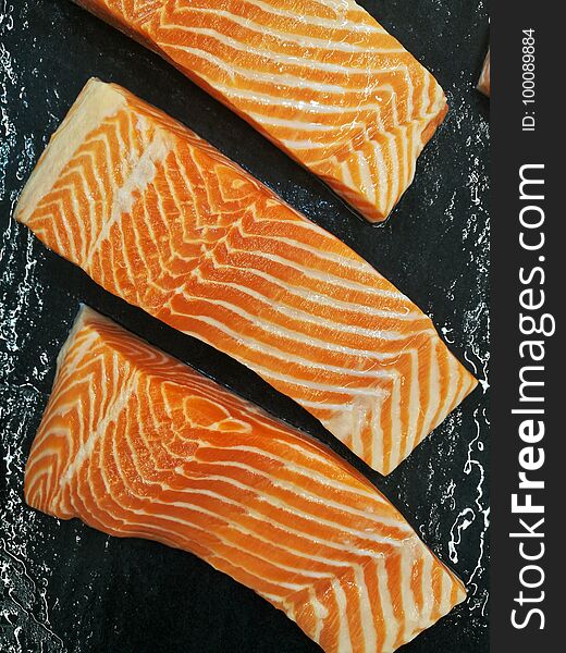 salmon fillet in front of black background