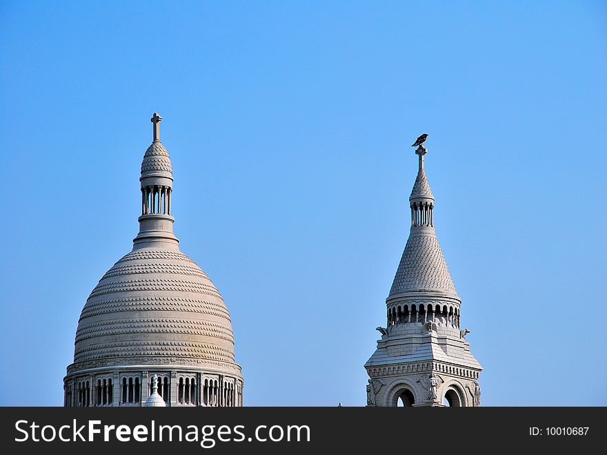 White, European style church architecture with bird perched on roof