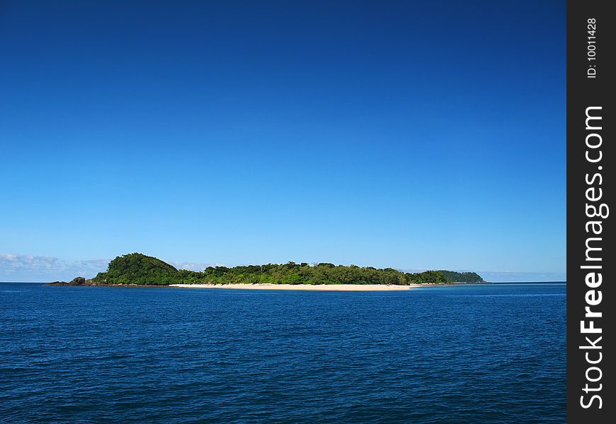 A tropical island paradise against a clear blue sky