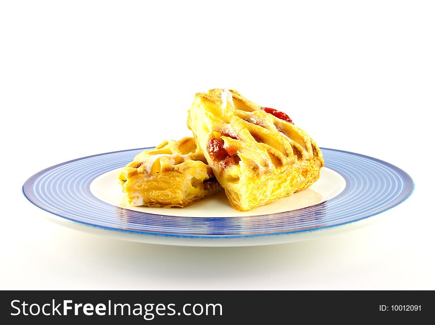 Raspberry and custard danish on a blue and white plate on a white background. Raspberry and custard danish on a blue and white plate on a white background