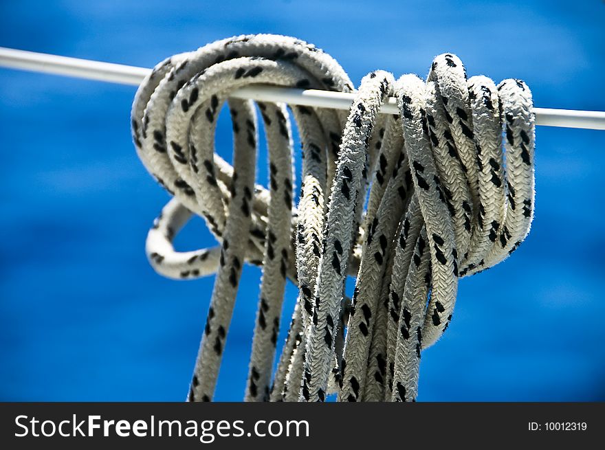 A photo of a rope tied off to a boat stay, against the blue of the sea. A photo of a rope tied off to a boat stay, against the blue of the sea