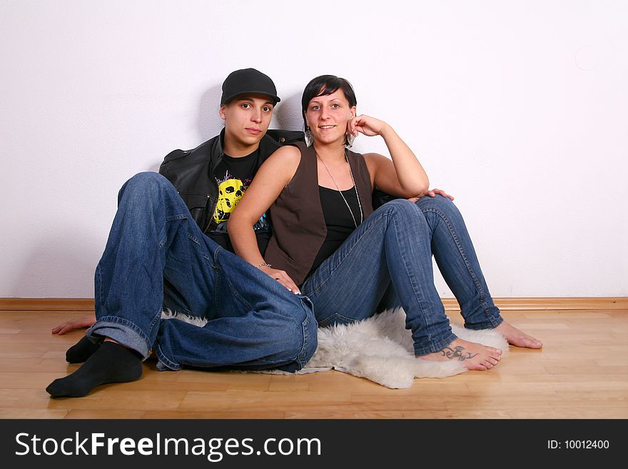 Young stylish couple sitting on the floor of their new home!. Young stylish couple sitting on the floor of their new home!