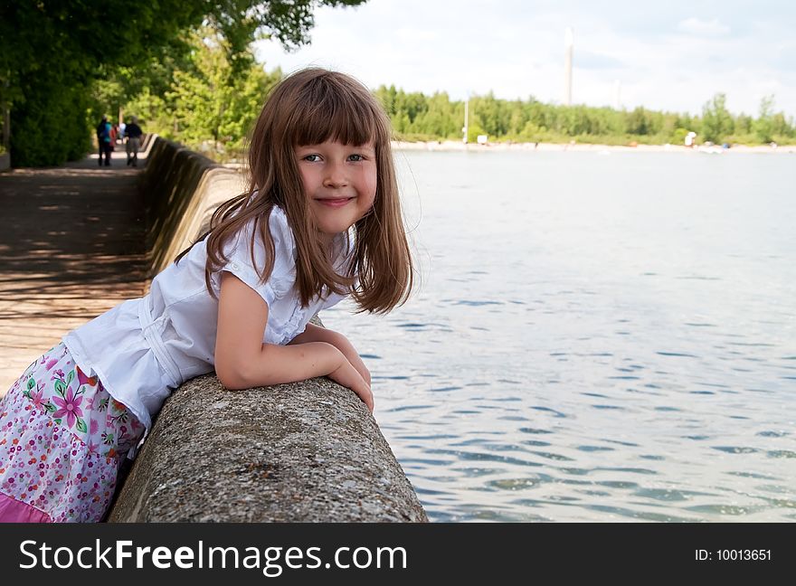 Smiling cute little girl on the lake