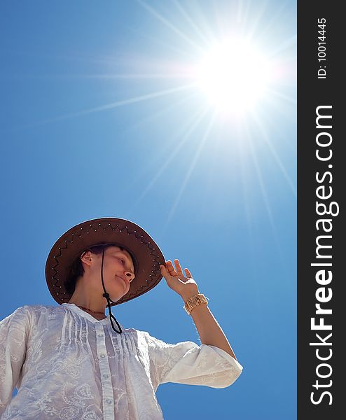 Beautiful young woman with hat on the sunny sky background. Beautiful young woman with hat on the sunny sky background