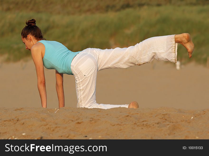 Woman doing yoga workout at the beach. Woman doing yoga workout at the beach