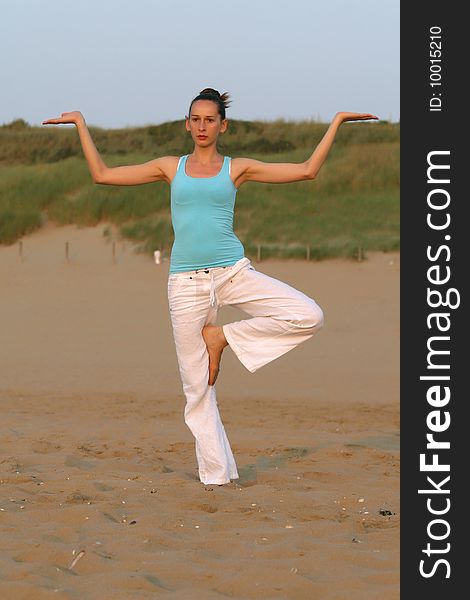 Woman doing yoga workout at the beach. Woman doing yoga workout at the beach