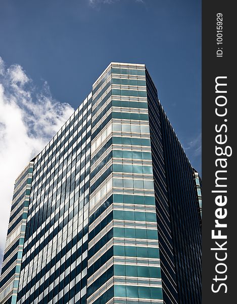 Glass building with blue sky and white clouds