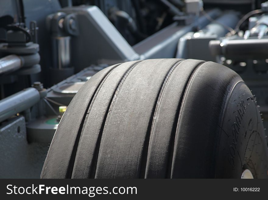 Close up of Airplane wheel profile in front of mechanical looking background