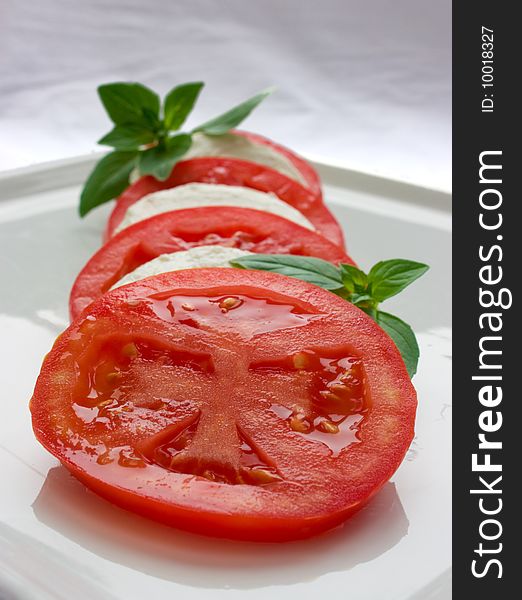 Tomato and cheese symmetrically arranged into salad. Tomato and cheese symmetrically arranged into salad
