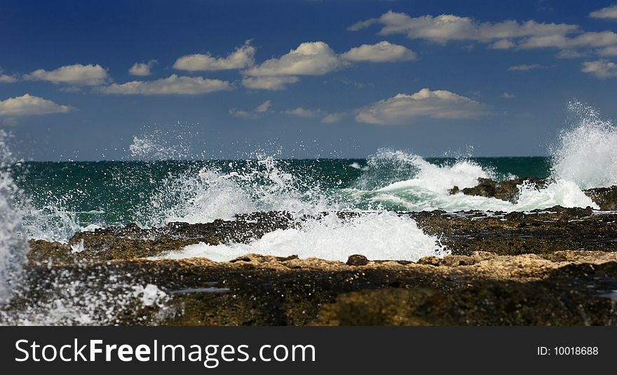 Sea waves break about stones