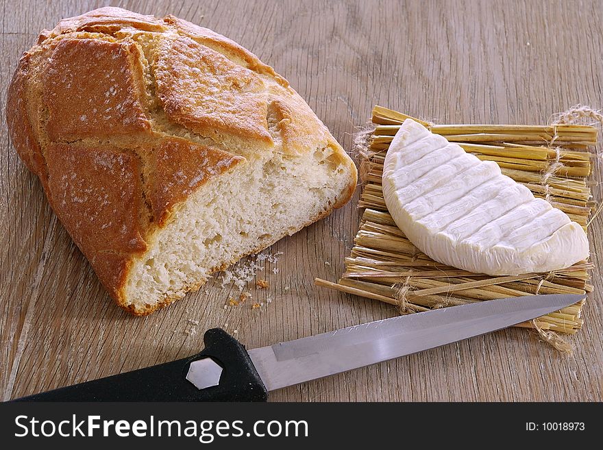 Bread, cheese and knife on a wood background