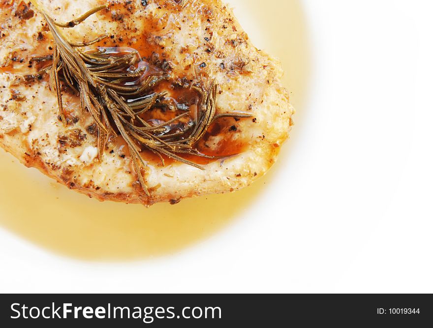 Rosemary chicken breast on a white plate with wood table background. Rosemary chicken breast on a white plate with wood table background.