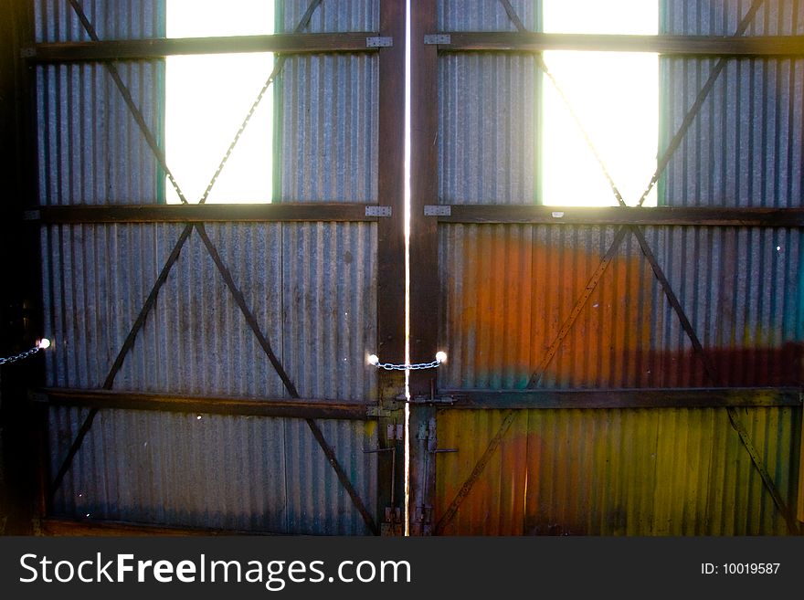 Light comes through the windows of two doors at a warehouse building. Light comes through the windows of two doors at a warehouse building.