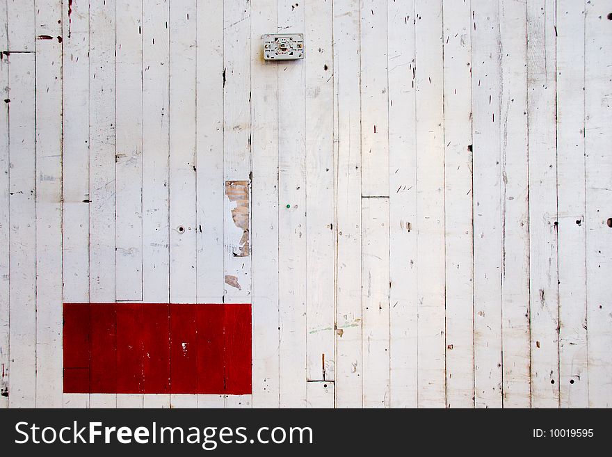 A very simple photo of a white wall with lines in the paint and a red rectangle of color. A very simple photo of a white wall with lines in the paint and a red rectangle of color.