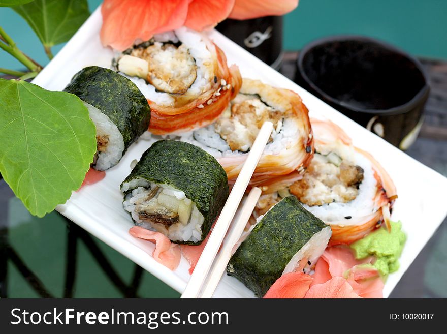 Sushi rolls  with chopsticks  and sake set close up. Sushi rolls  with chopsticks  and sake set close up