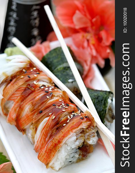 Sushi rolls  with chopsticks  and sake set close up. Sushi rolls  with chopsticks  and sake set close up