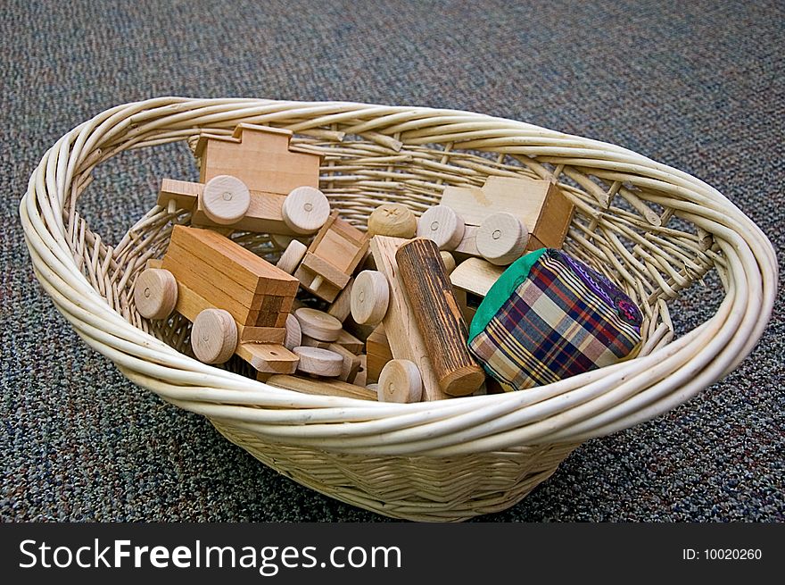This wicker basket is full of handmade toys, a fabric square ball, and a wooden train. This wicker basket is full of handmade toys, a fabric square ball, and a wooden train.