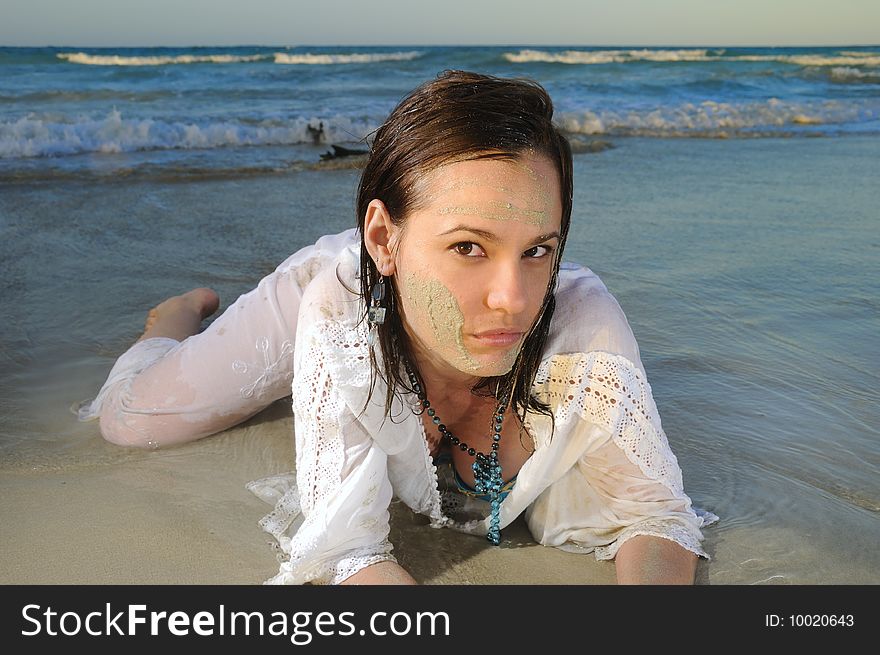 Portrait of young fashion woman lying on the sand of tropical beach. Portrait of young fashion woman lying on the sand of tropical beach