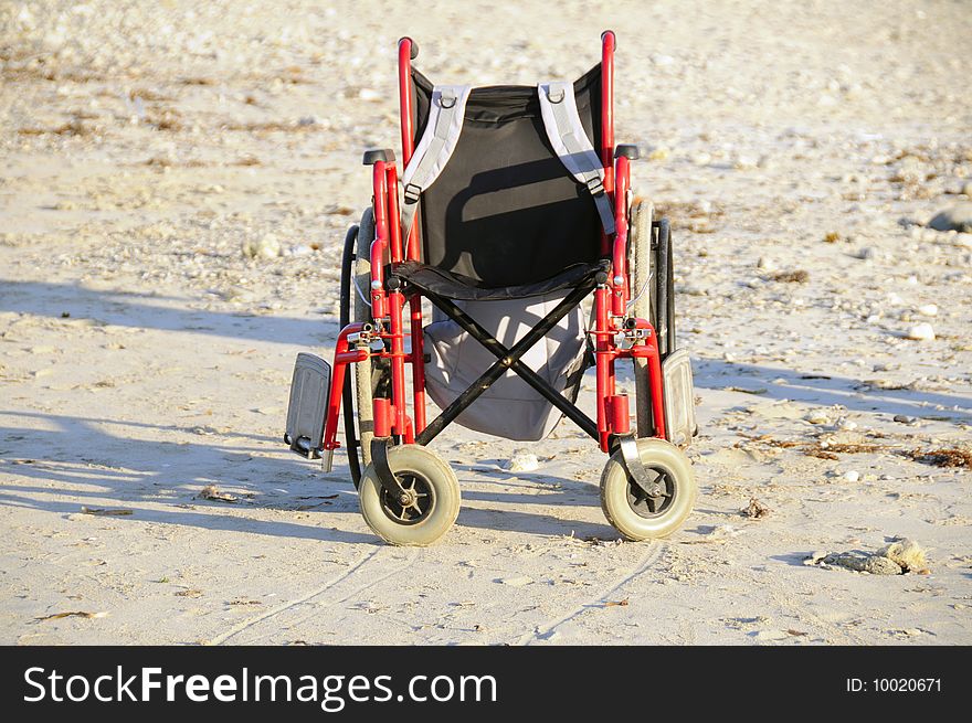 Empty wheelchair on the sand of tropical beach