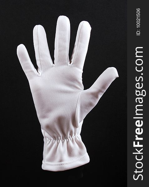 Open left hand in white glove on black background.