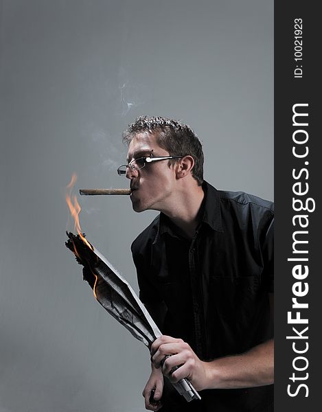 Man lights cigar with a burning newspaper.