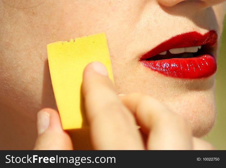 An image of a young woman making up her face. An image of a young woman making up her face