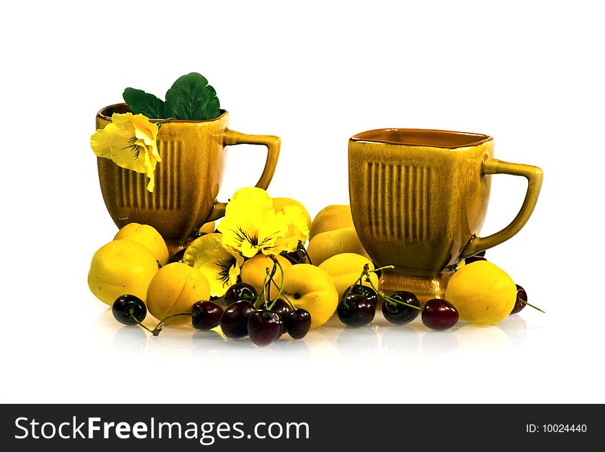 Composition from yellow ripe an apricot and cherries with cups. Composition from yellow ripe an apricot and cherries with cups