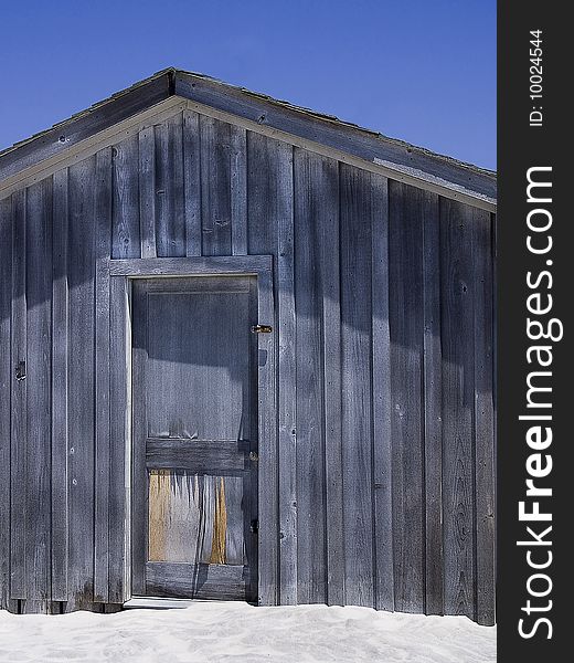 A shuttered up shack sits on a beach. A shuttered up shack sits on a beach