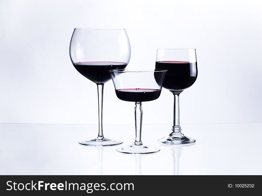 Three glasses with red wine on white background