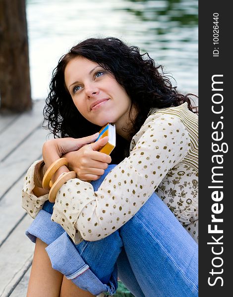 Outdoor portrait of a beautiful woman with a book