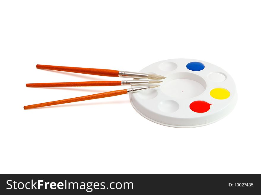 Round kids' palette with three paintbrushes isolated