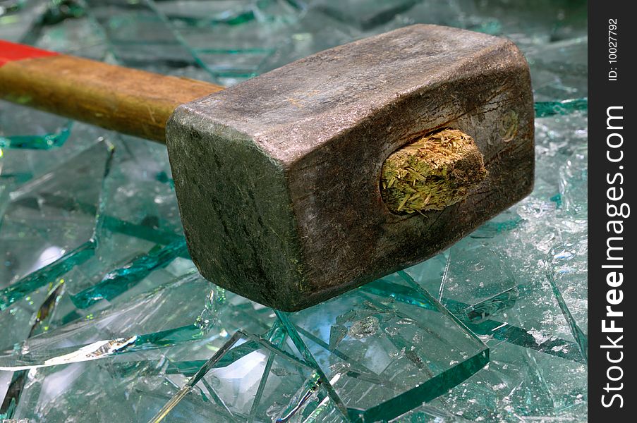 Sledge hammer lies on beaten glass. Sledge hammer lies on beaten glass.