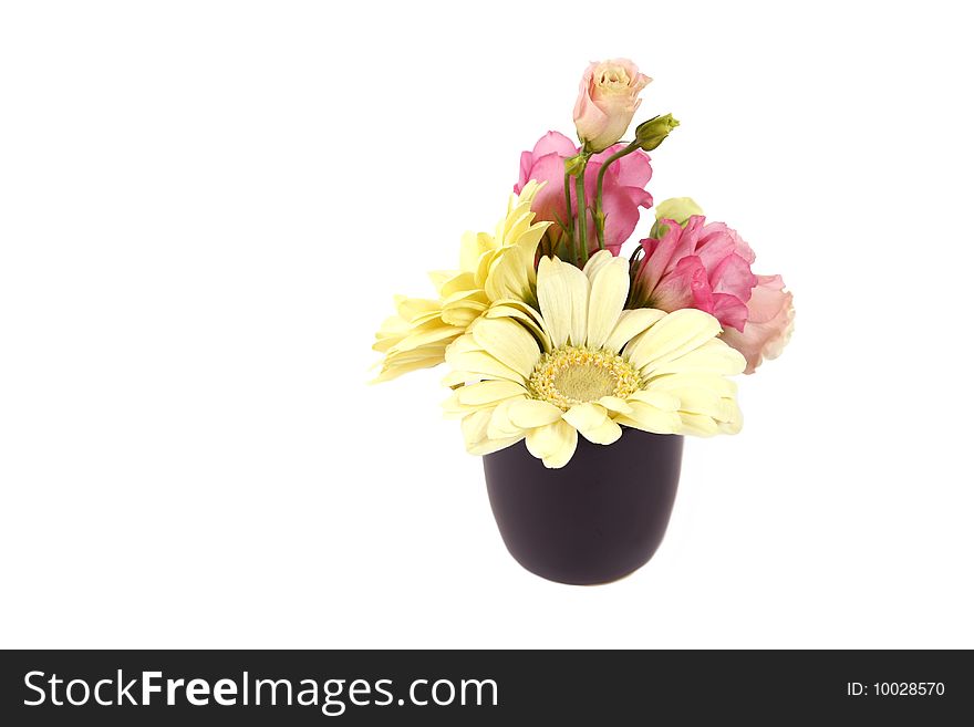 Bouquet of white flowers and roses in a black pot.