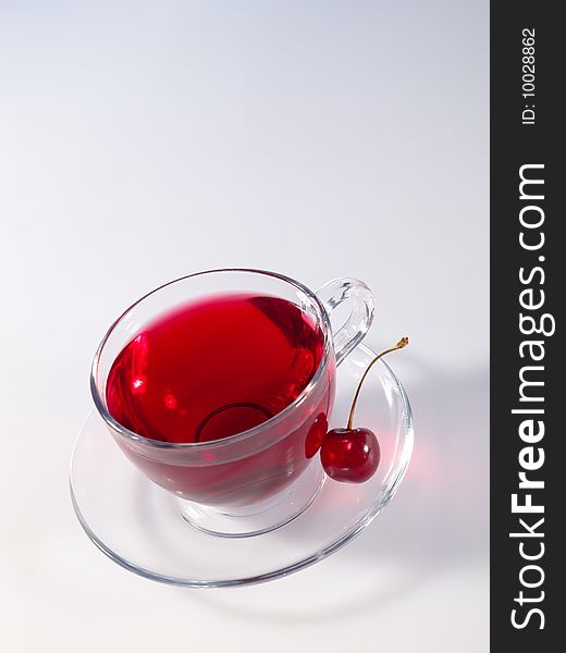 Hibiscus herbal tea in glass cup with ripe tasty cherry