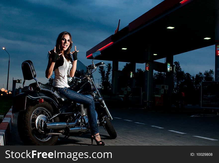 Model on the motorcycle on gas station, night shot. Model on the motorcycle on gas station, night shot