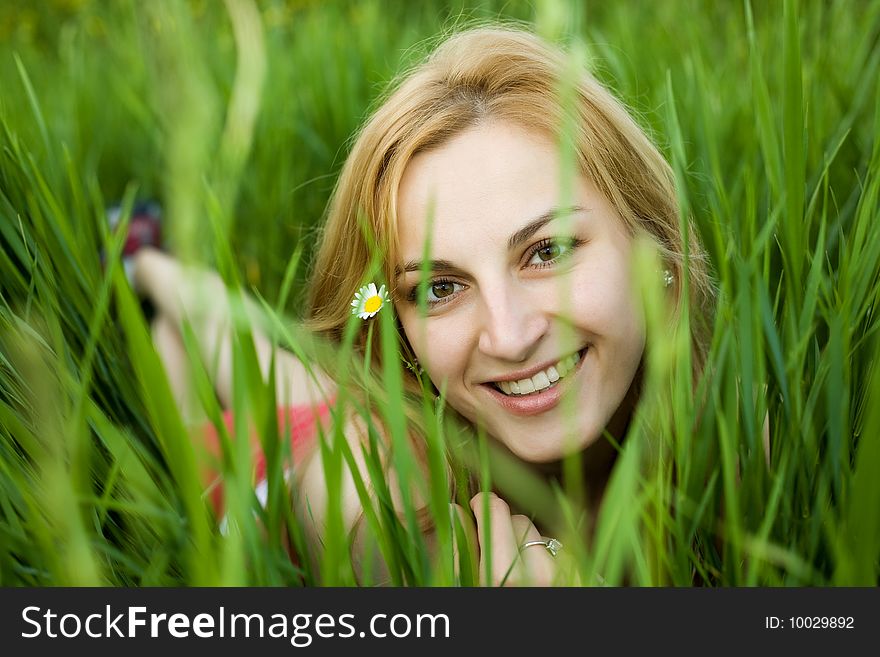 An image of a young girl in the green grass. An image of a young girl in the green grass