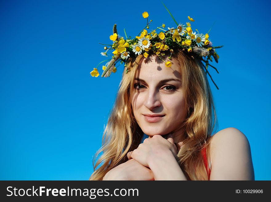 A pretty woman in a chaplet of yellow flowers and chamomiles