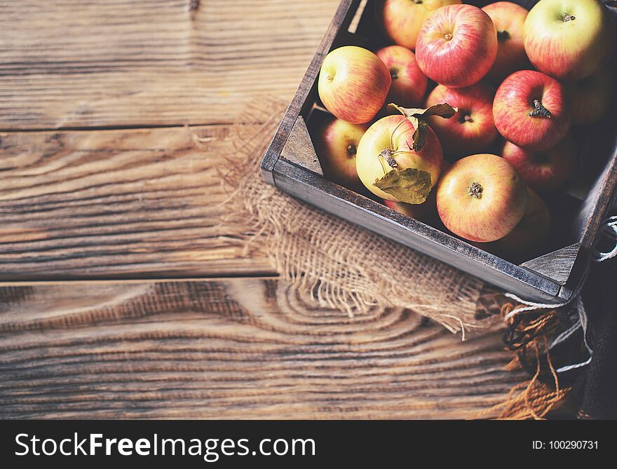 Ripe Apples In Box With Plaid On Wooden Background