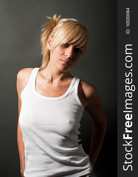 Portrait of attractive blond girl in shirt over dark with shadows. Portrait of attractive blond girl in shirt over dark with shadows