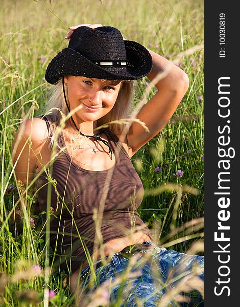 Young blond cowgirl lying in grass. Young blond cowgirl lying in grass