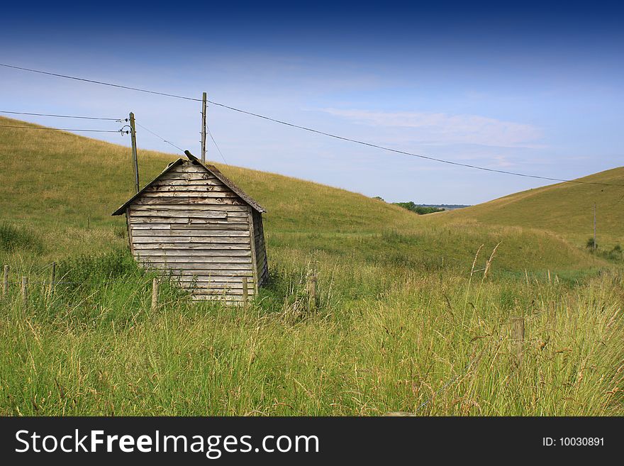 An isolated wooden hut set in a rural valley landscape in Wiltshire, England. An isolated wooden hut set in a rural valley landscape in Wiltshire, England.
