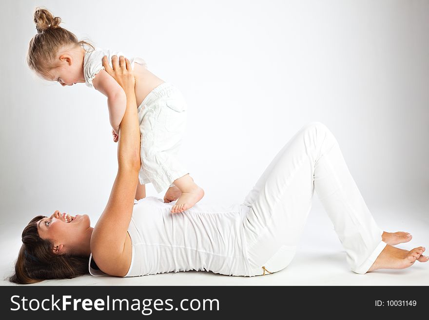 Mother and her little daughter. Gray background