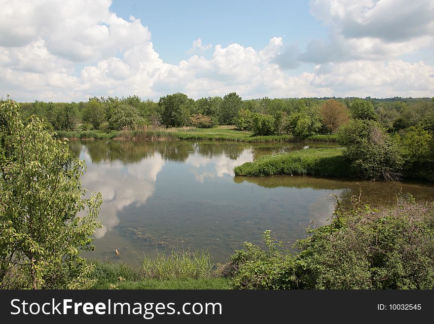 In a silent smooth surface of lake clouds are reflected. In a silent smooth surface of lake clouds are reflected