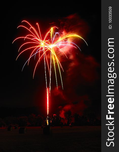 Fireworks exploding over hay field. Fireworks exploding over hay field